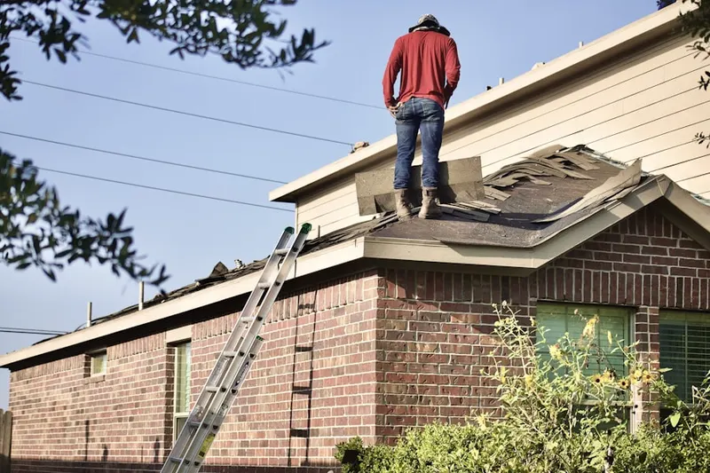 Professional roofer working on a residential roof in Erskine